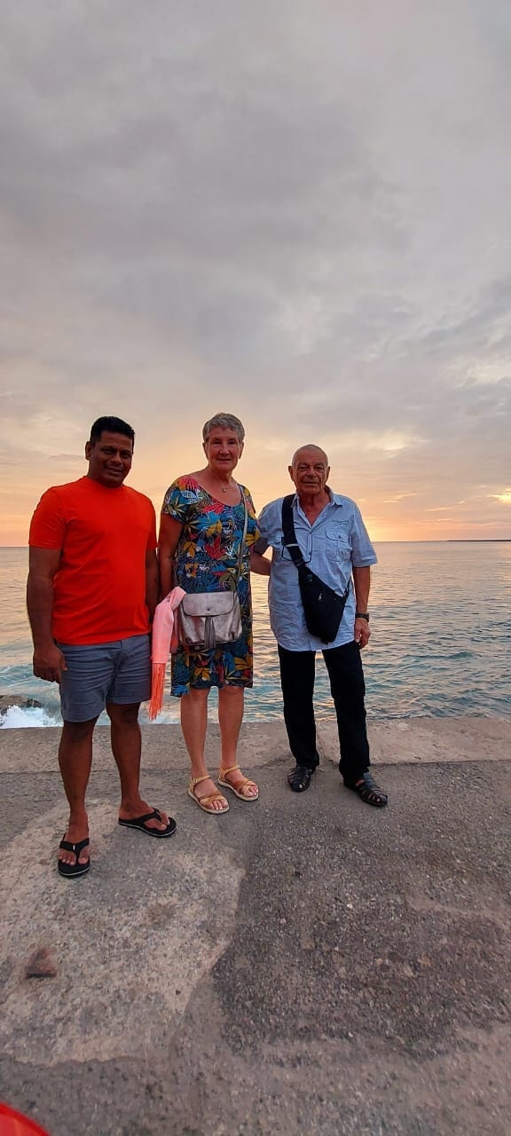Guests and their guide beside the Indian Ocean at sunset